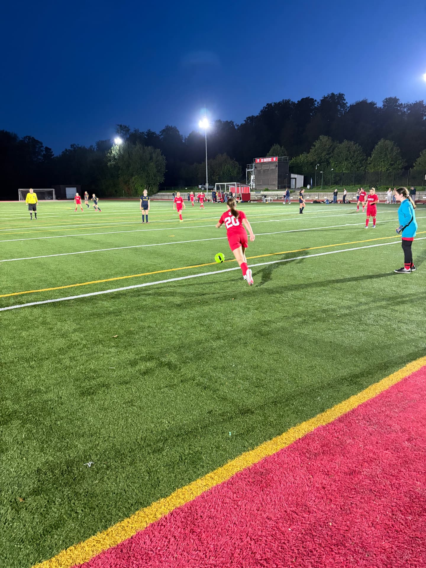 U14 girls soccer player passing under the lights