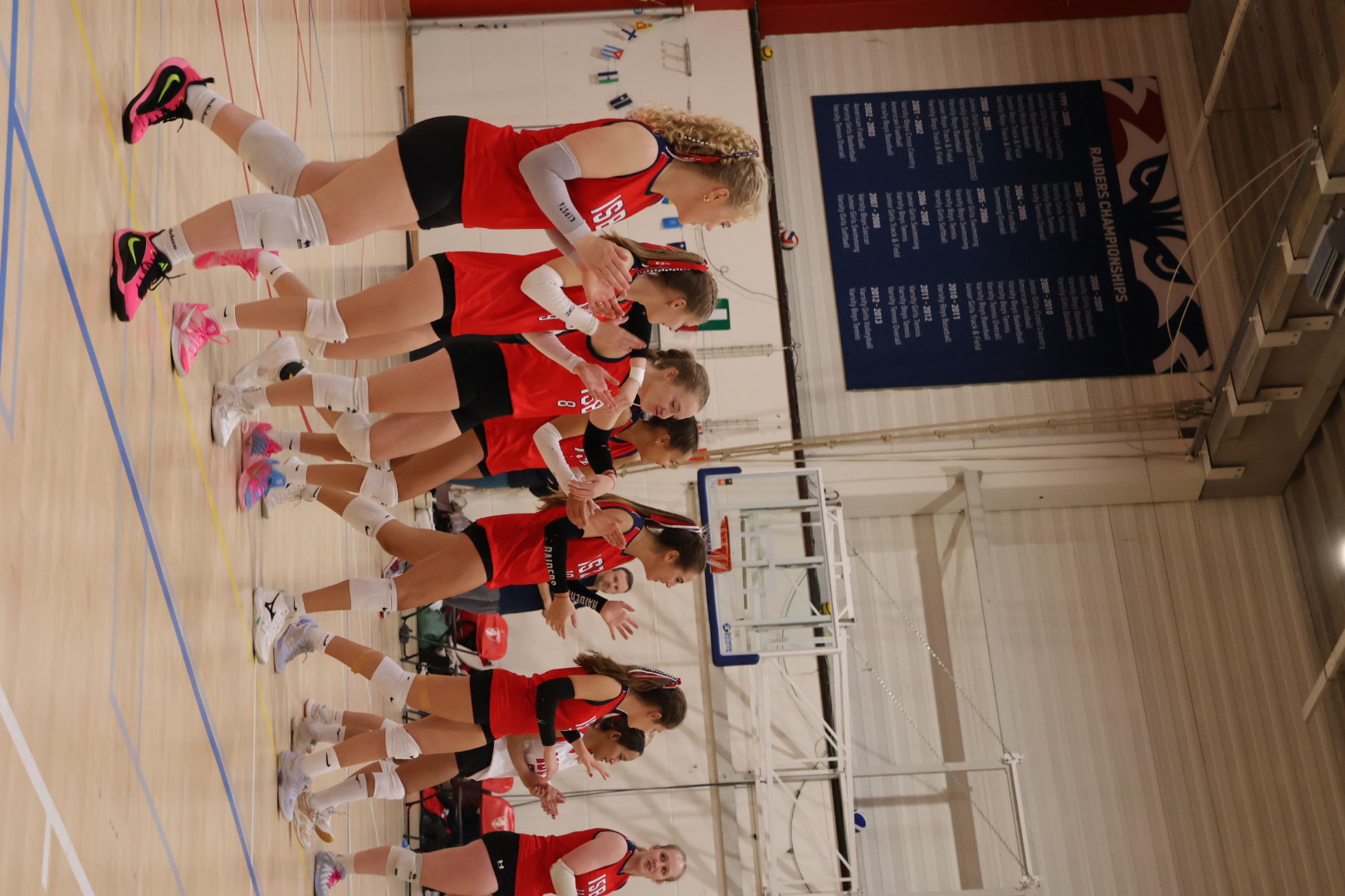 Raiders volleyball team celebrating on court