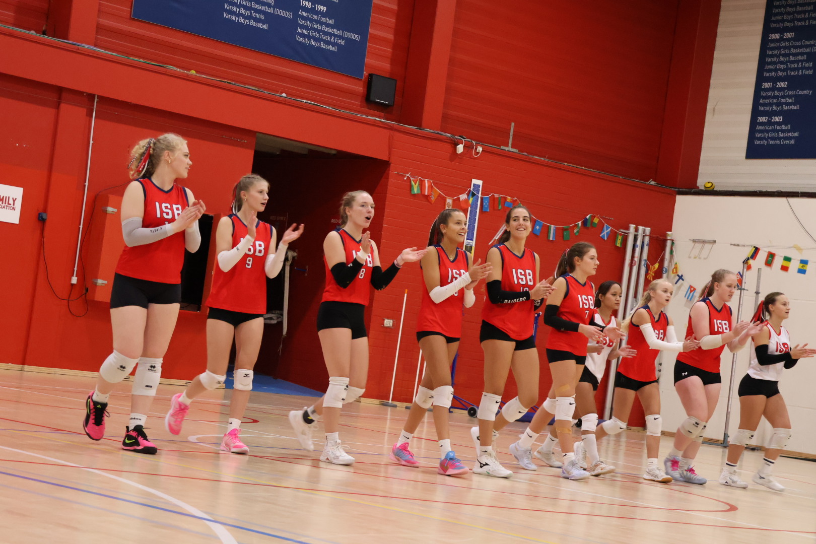 Raiders volleyball players applauding together on court