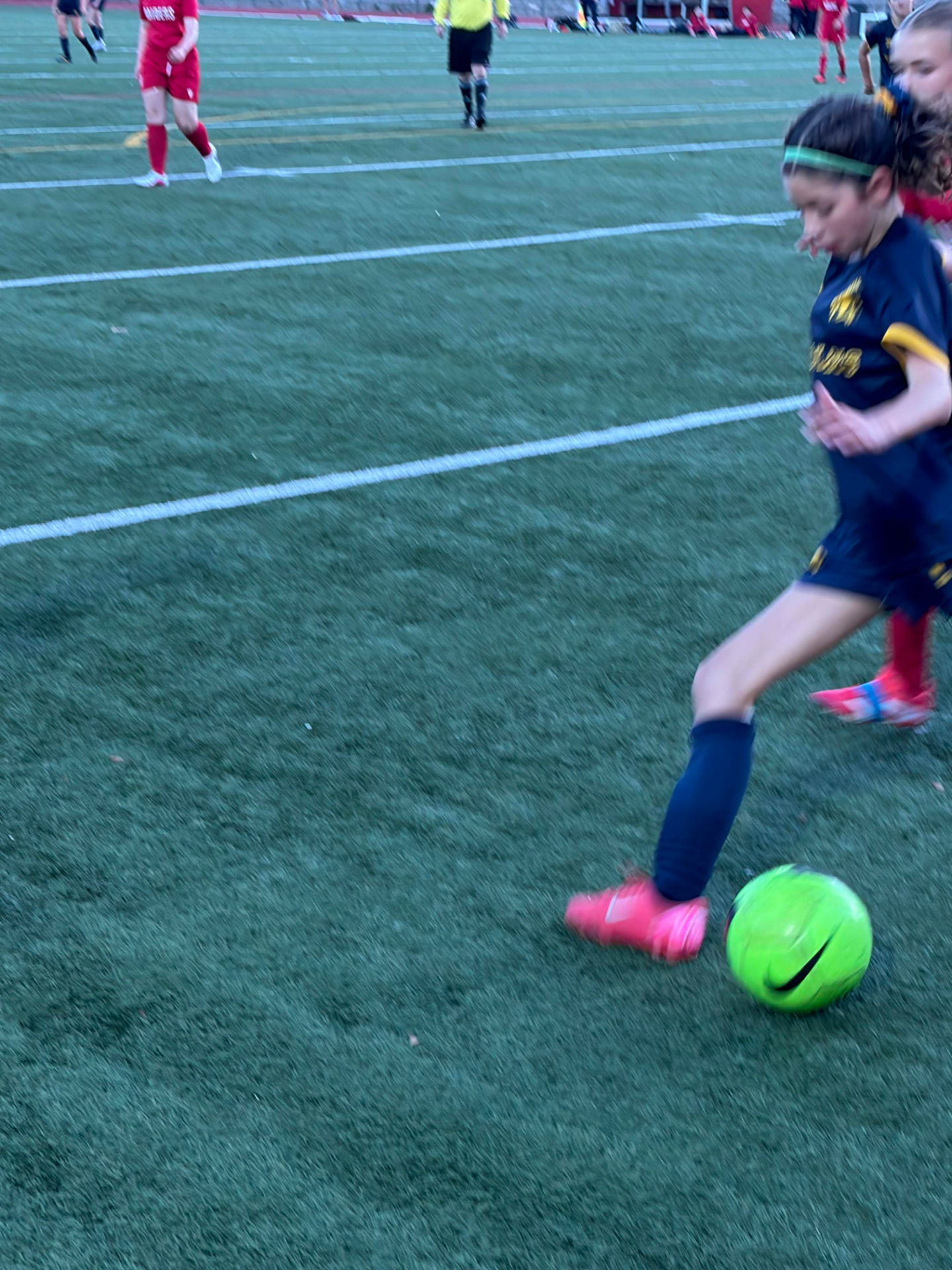 U14 soccer player dribbling forward
