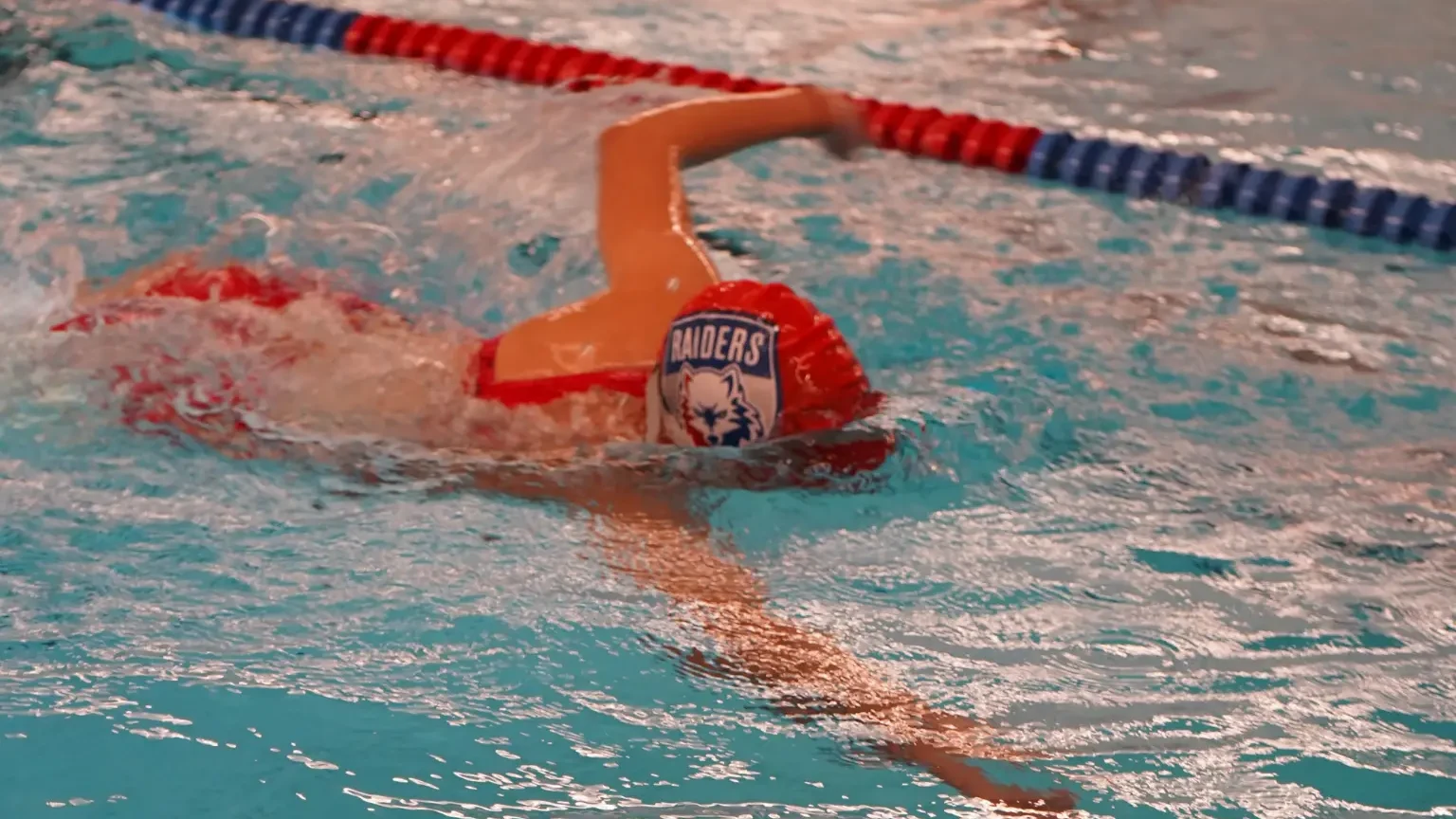 Raiders swimmer racing in the ISB pool