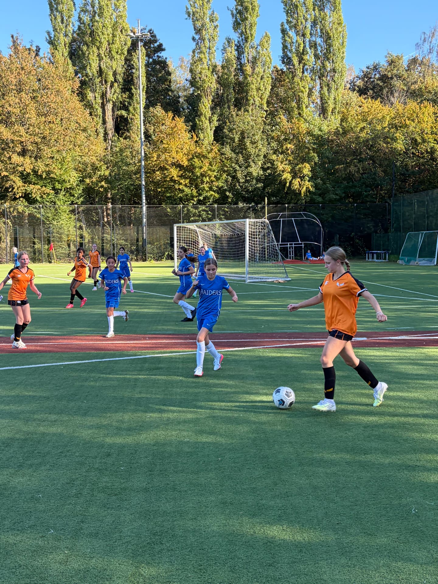 U14 girls soccer player carrying the ball down the wing